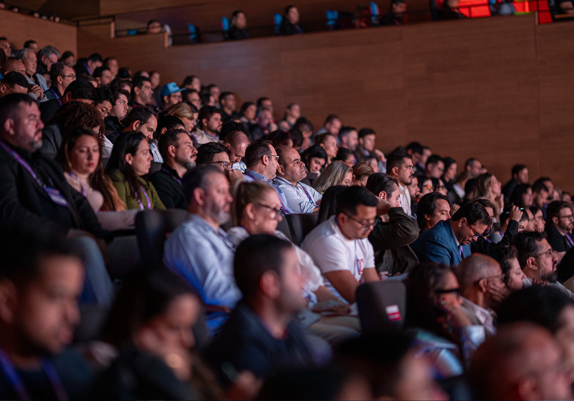 Um grande público senta-se junto em um auditório pouco iluminado, assistindo atentamente a uma apresentação inédita do Acelera Food Nation - talvez antecipando a edição de 2026 ou esperando subir na Lista de Espera.